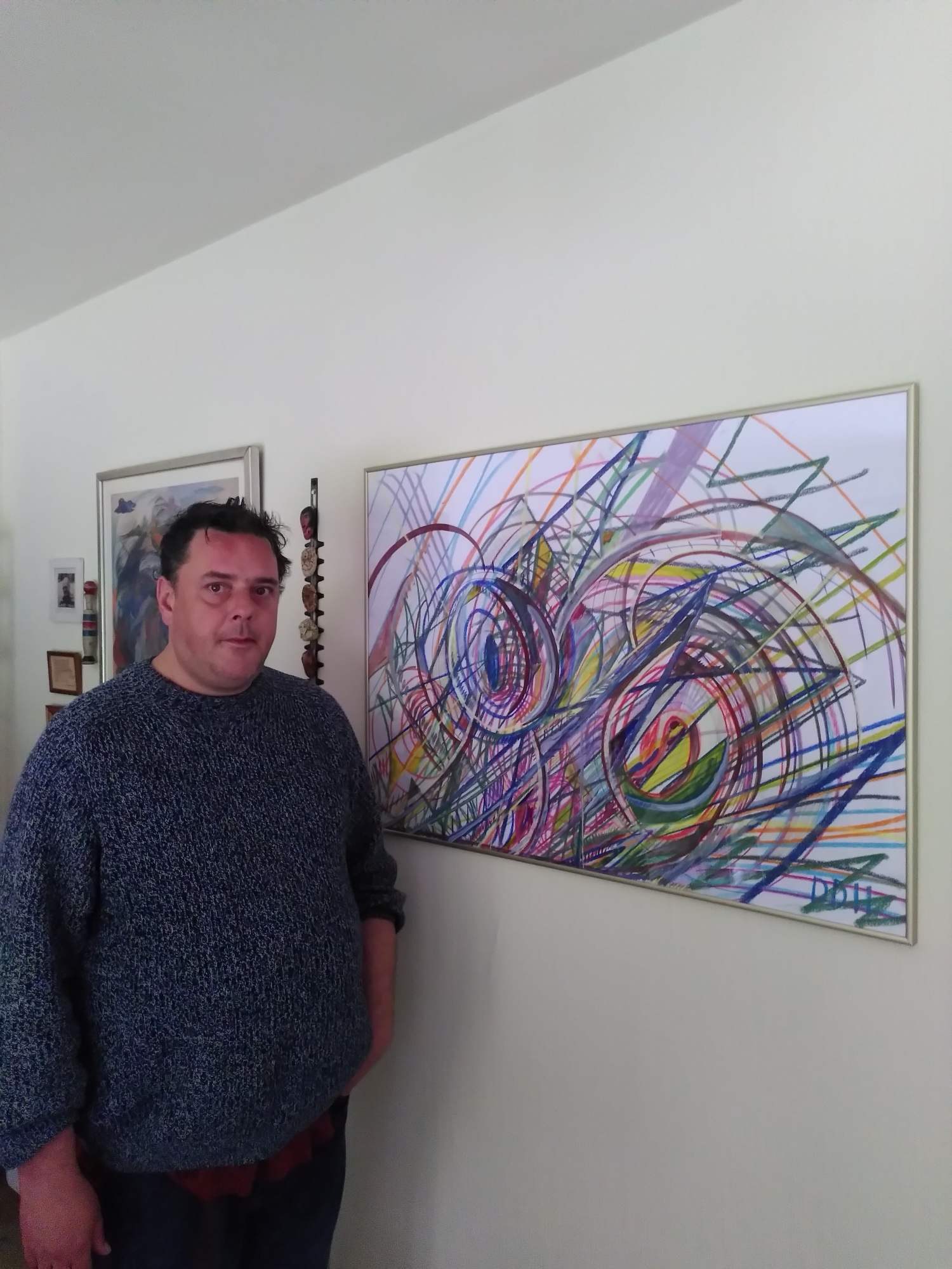 David De Henau naast een van zijn grote tekeningen aan de muur